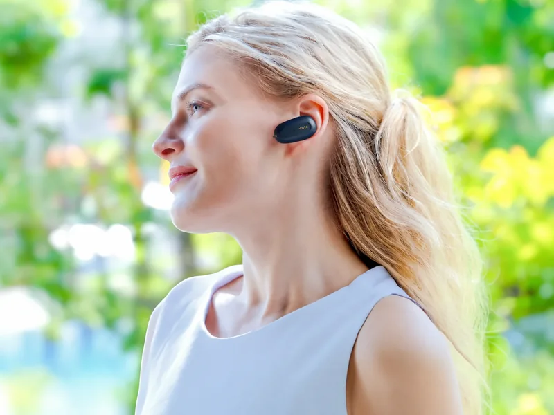 ผู้หญิงสวมหูฟัง Airvida T1S สี Midnight Blue กลางแจ้งในสวน